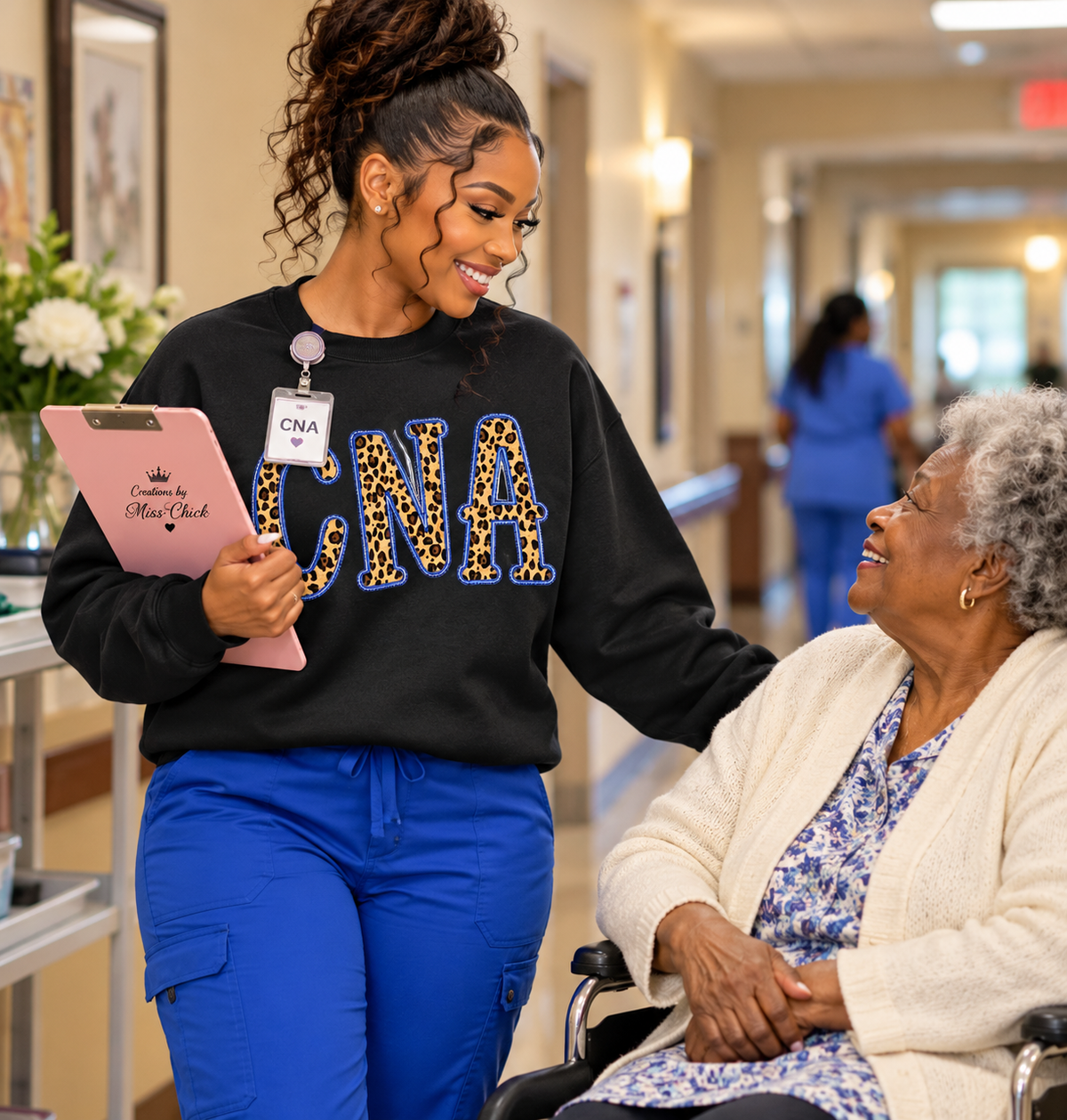 Young CNA wearing leopard print sweatshirt speaking with resident in nursing home